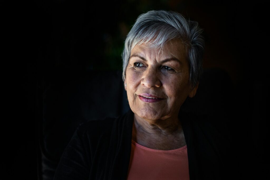 Elderly woman with gray hair looking thoughtfully, showcasing wisdom and grace.