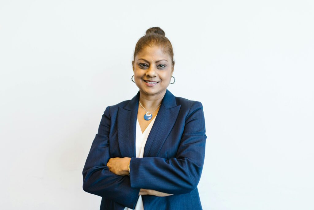 Portrait of a confident businesswoman in professional attire with a friendly smile, arms crossed.